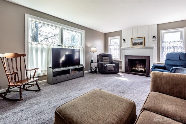 living area with carpet, a fireplace, and baseboards