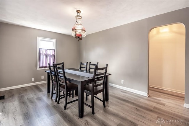 dining space featuring visible vents, baseboards, and wood finished floors