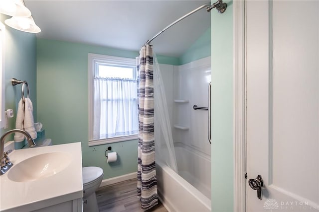 bathroom featuring baseboards, toilet, wood finished floors, shower / bath combination with curtain, and vanity