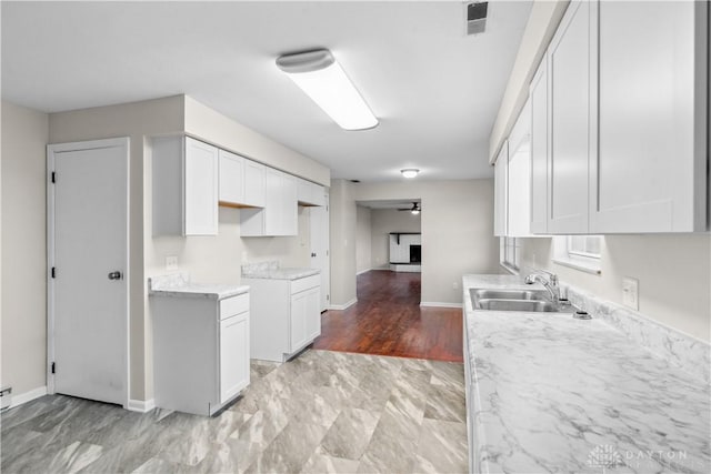 kitchen featuring white cabinetry, visible vents, a sink, and ceiling fan