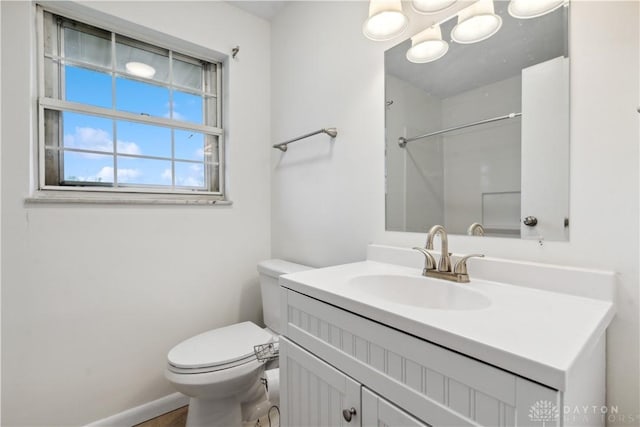 bathroom featuring baseboards, vanity, and toilet