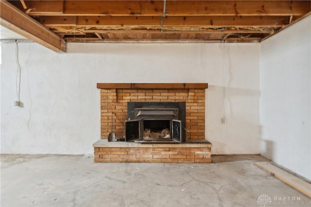 interior details with unfinished concrete flooring and a brick fireplace