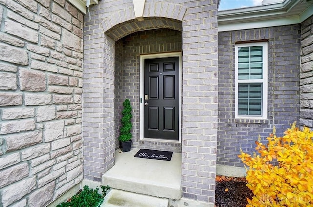 doorway to property with brick siding