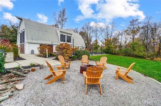 back of house featuring a yard, an outdoor fire pit, a patio, and a gambrel roof