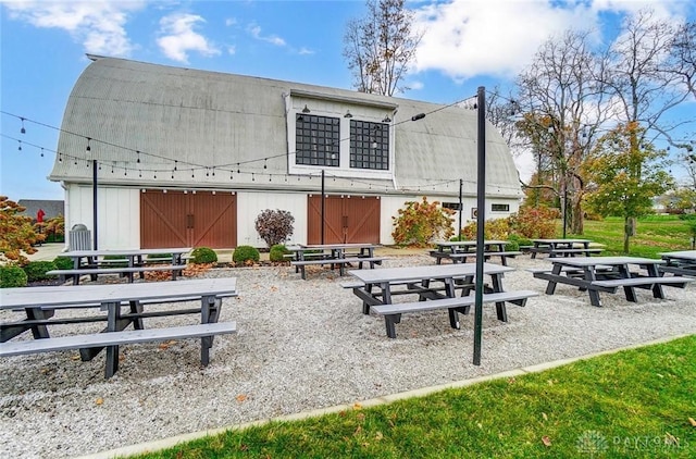 view of home's community featuring an outbuilding, a patio, and a barn