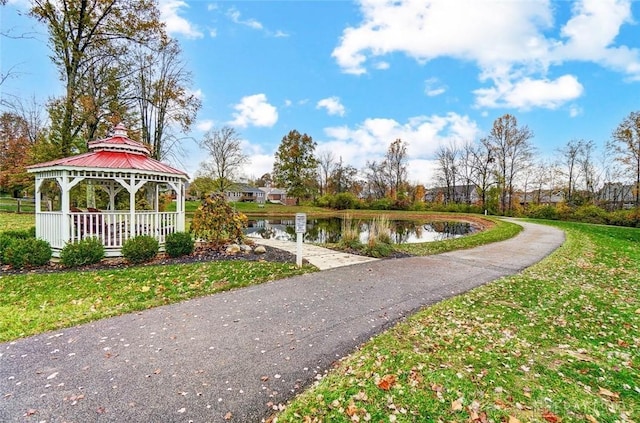 view of home's community with a water view, a yard, and a gazebo