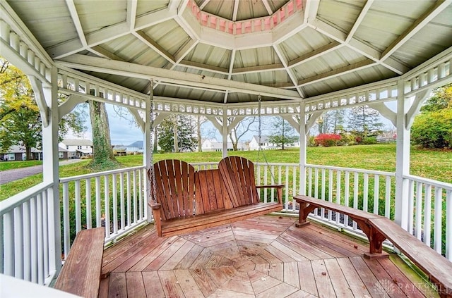 wooden terrace featuring a lawn and a gazebo