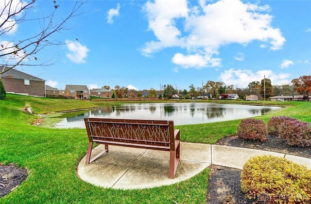 surrounding community with a water view and a lawn