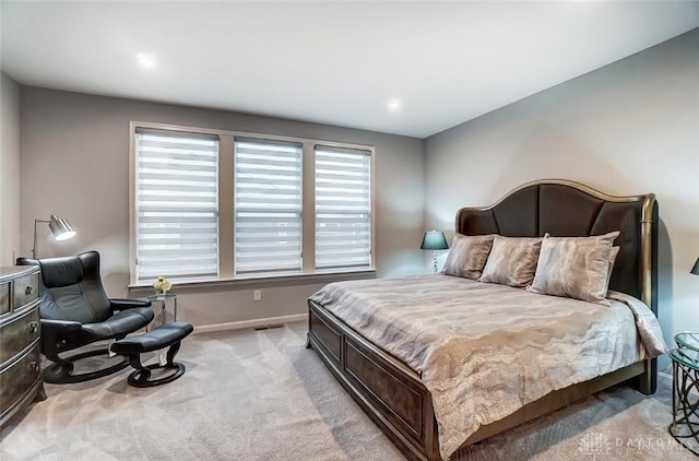 bedroom with visible vents, baseboards, and light colored carpet