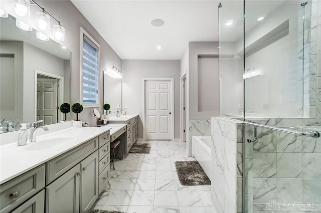 full bathroom with marble finish floor, a garden tub, a sink, and a stall shower