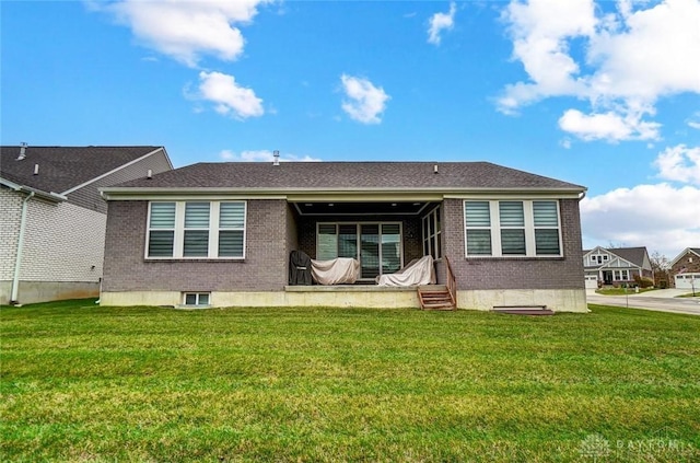 back of house featuring a yard and brick siding