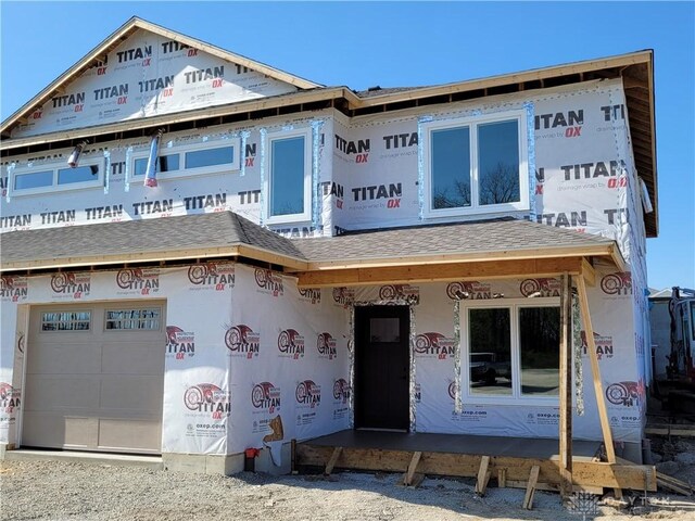 property under construction with a garage and a shingled roof