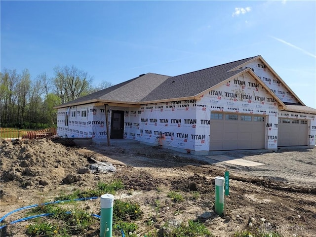 view of front facade featuring a shingled roof and an attached garage