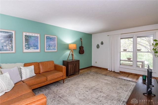 living room with baseboards and wood finished floors