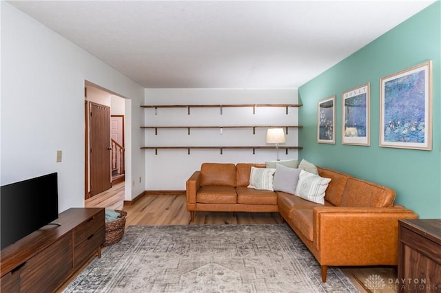 living area featuring stairway, wood finished floors, and baseboards