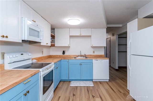 kitchen featuring blue cabinetry, white cabinetry, a sink, butcher block countertops, and white appliances