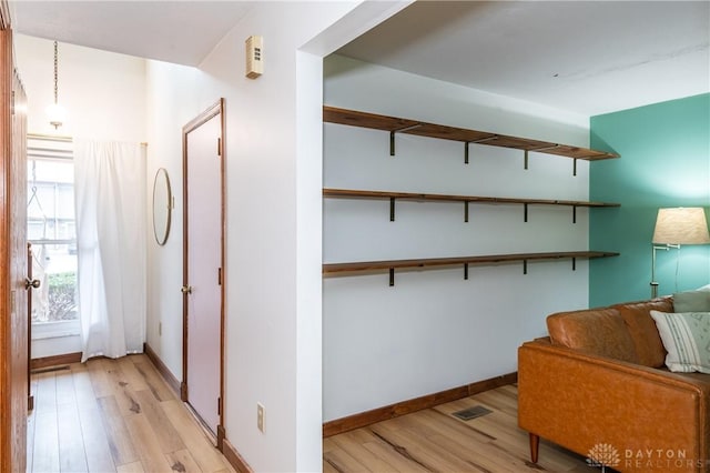 hall with baseboards and light wood finished floors