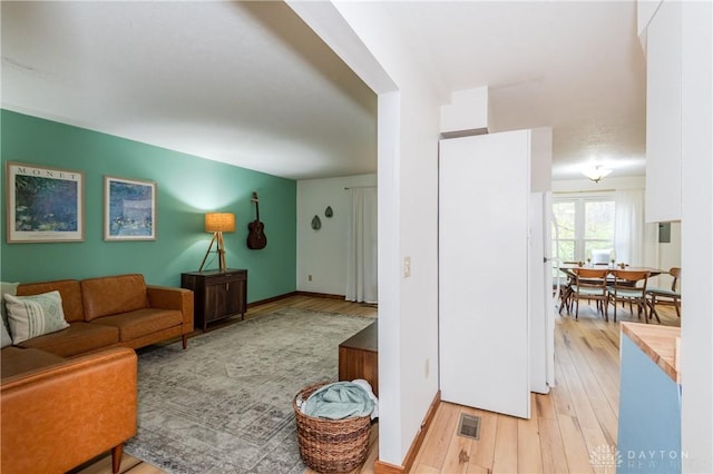 living room featuring light wood-type flooring and baseboards