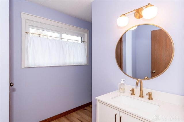 bathroom featuring vanity, baseboards, and wood finished floors