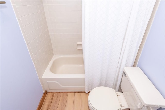 bathroom with toilet, shower / bath combination with curtain, and wood finished floors