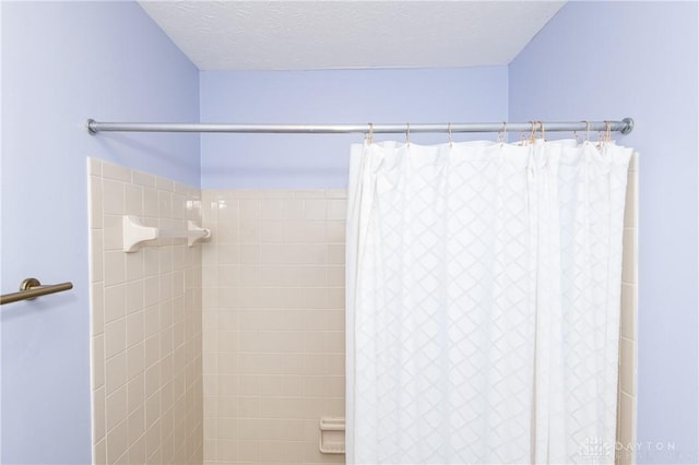 full bath featuring a textured ceiling and a shower with shower curtain