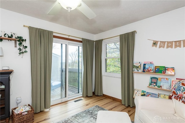 bedroom featuring visible vents, a ceiling fan, light wood-style flooring, and access to exterior