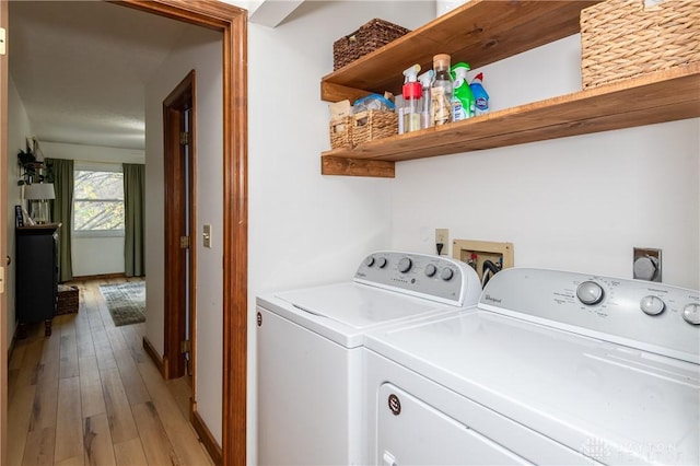 laundry room featuring laundry area, washing machine and clothes dryer, and light wood-style flooring