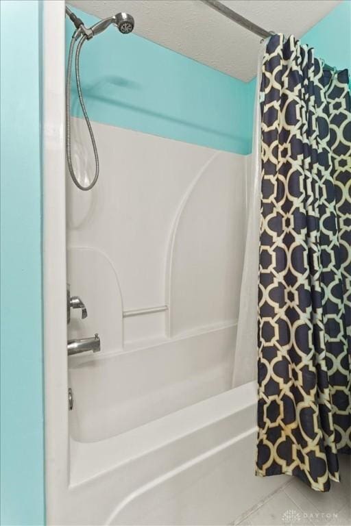 full bath with tile patterned flooring, shower / bath combo, and a textured ceiling