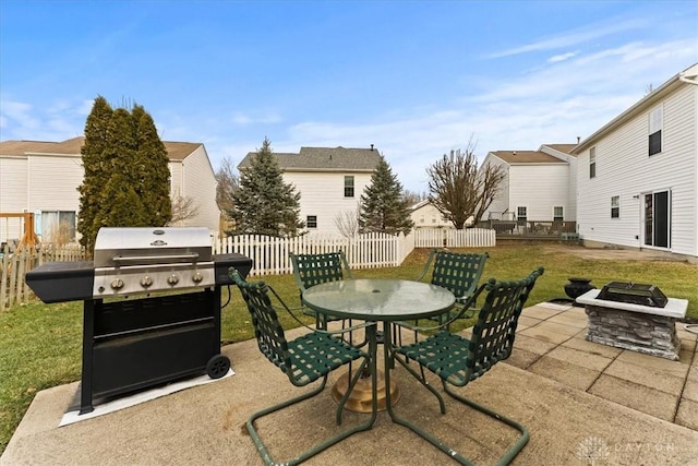 view of patio featuring fence, a fire pit, outdoor dining area, and area for grilling