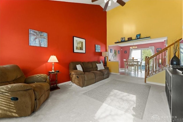 carpeted living room featuring high vaulted ceiling, an accent wall, baseboards, and a ceiling fan