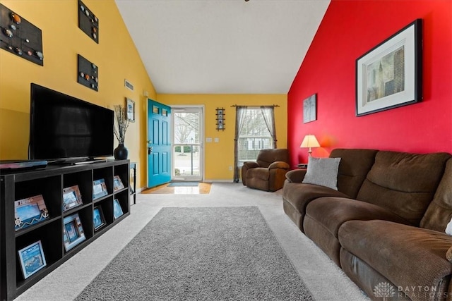 living room featuring an accent wall, high vaulted ceiling, carpet flooring, and baseboards