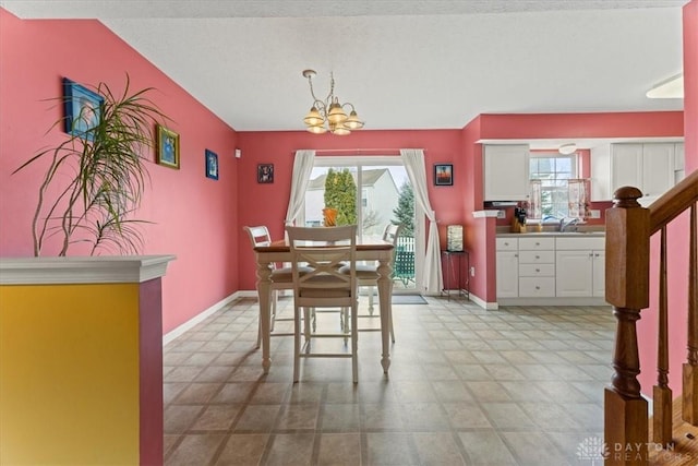 dining space featuring a chandelier, a healthy amount of sunlight, and baseboards