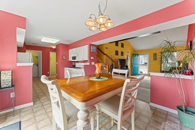 dining space with light floors, an inviting chandelier, vaulted ceiling, baseboards, and stairs