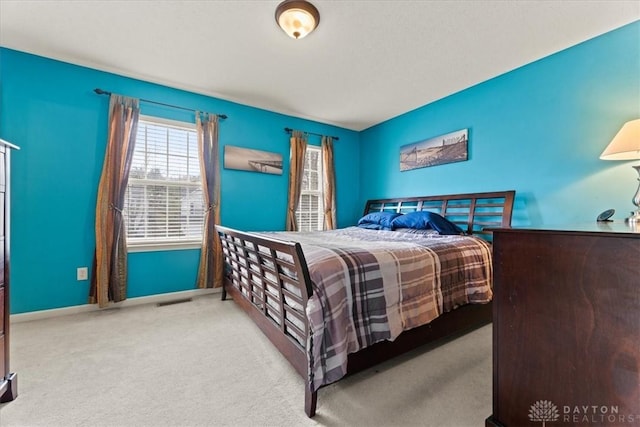 carpeted bedroom with visible vents and baseboards