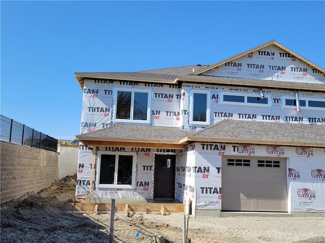 unfinished property featuring fence and a shingled roof