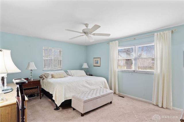 bedroom featuring a ceiling fan, light colored carpet, and baseboards