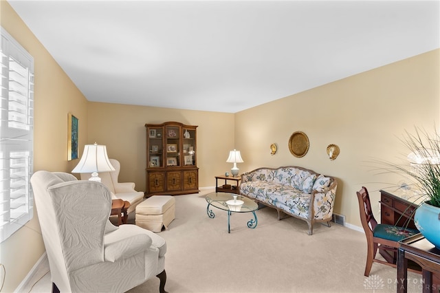 living room with carpet flooring, visible vents, and baseboards