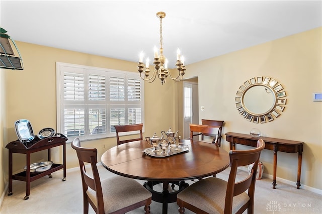 dining space with light carpet, baseboards, and a notable chandelier