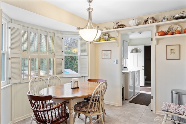 dining room featuring baseboards, washing machine and clothes dryer, and light tile patterned floors