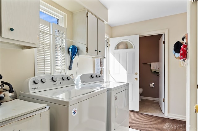 laundry room with separate washer and dryer, cabinet space, and baseboards