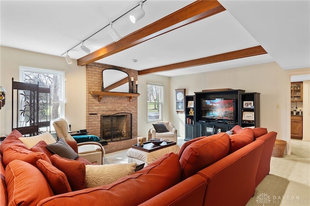 carpeted living area with beam ceiling, a fireplace, and plenty of natural light