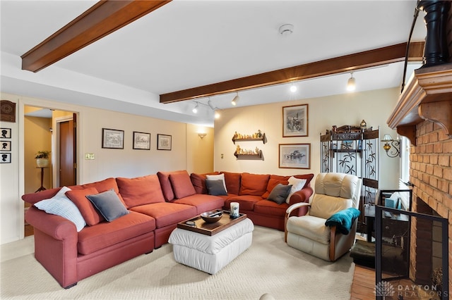 living area featuring a brick fireplace, rail lighting, and beam ceiling