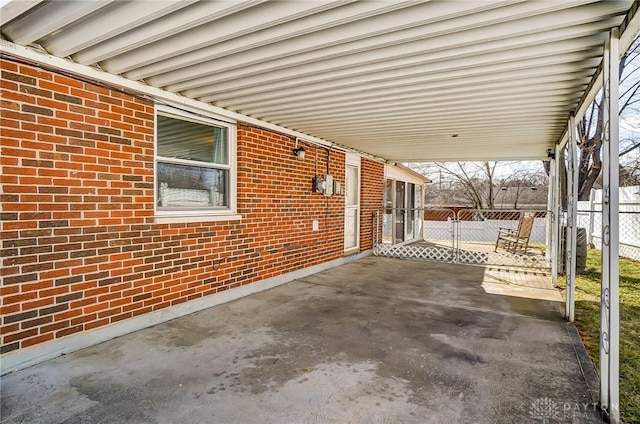 view of patio / terrace with a gate, fence, and an attached carport