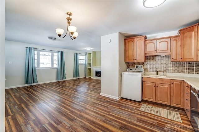 kitchen with washer / dryer, open floor plan, dark wood finished floors, and tasteful backsplash