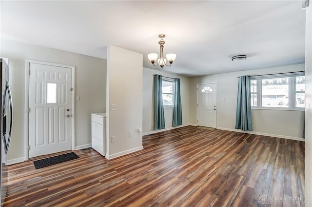 entrance foyer featuring baseboards, a notable chandelier, wood finished floors, and a healthy amount of sunlight