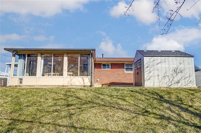 back of house featuring a yard, brick siding, and a sunroom