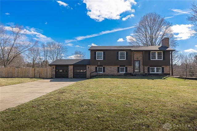 split foyer home featuring driveway, a chimney, an attached garage, fence, and a front lawn