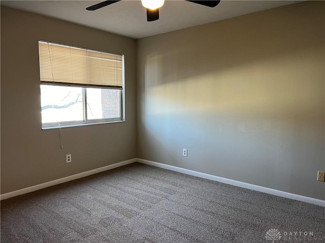 carpeted empty room featuring baseboards and a ceiling fan