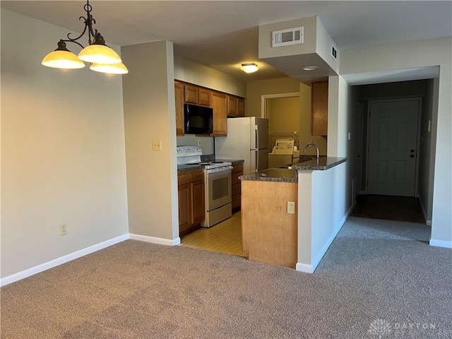 kitchen with light carpet, a peninsula, white appliances, visible vents, and brown cabinets