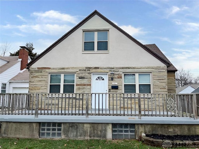 back of property with a porch and stucco siding